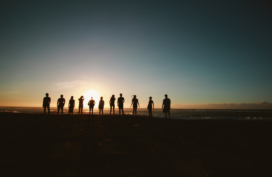 A group of people celebrating in the sunset representing how group therapy can transform your life